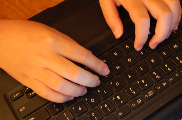 prsty na černé klávesnici, obě ruce